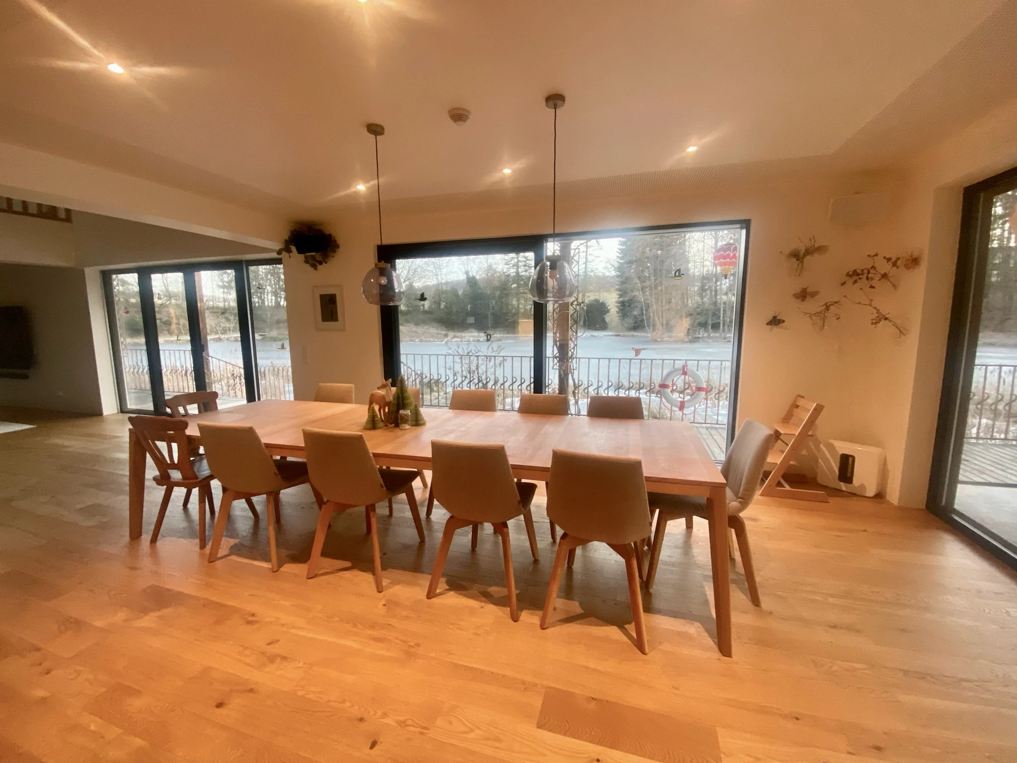 Großer Holztisch mit Sitzplätzen und Blick in den Garten